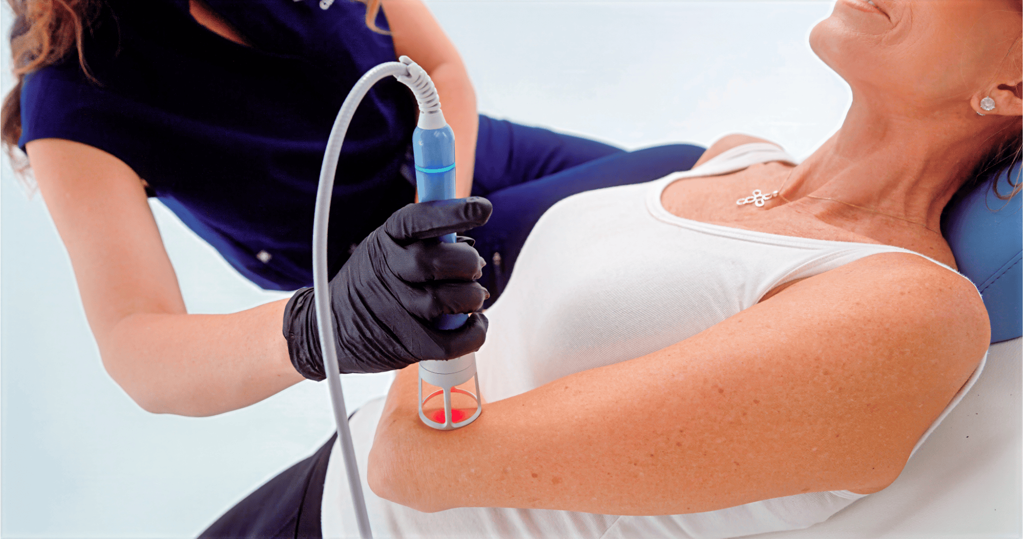 Provider placing the Emvital laser treatment for pain relief on her patient's arm. This is offered in addition to Exomind, a therapy for anxiety in Abilene.
